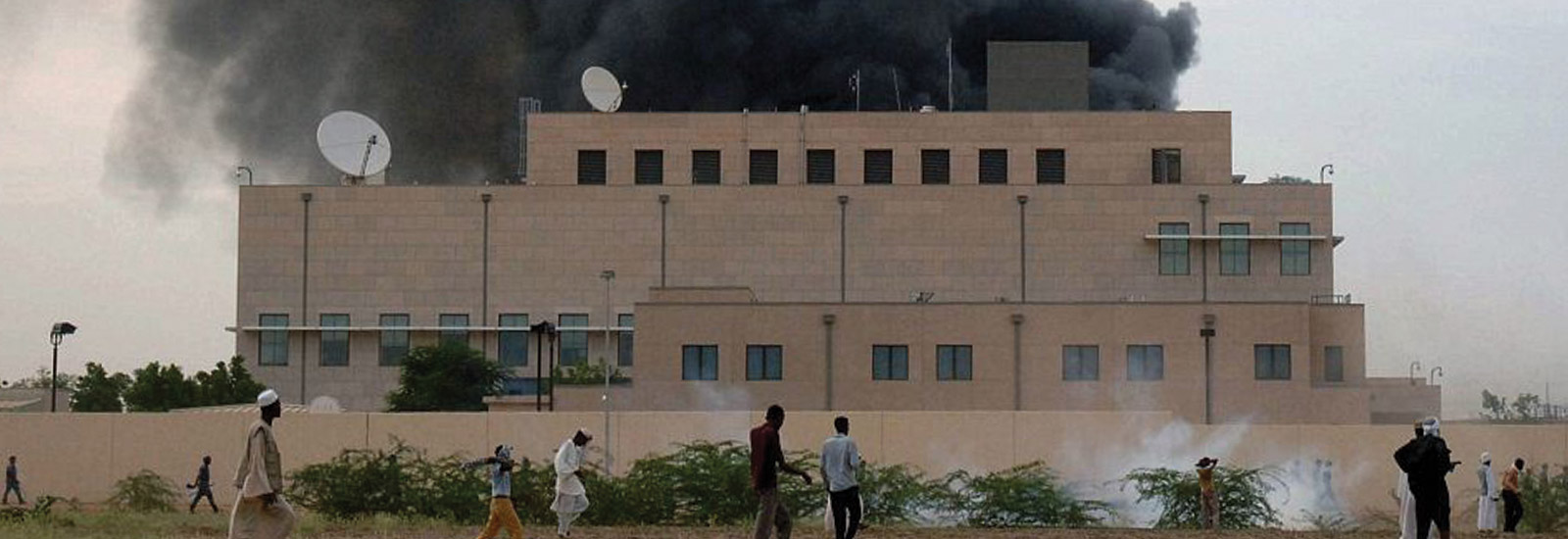 Image of a large embassy building with black smoke